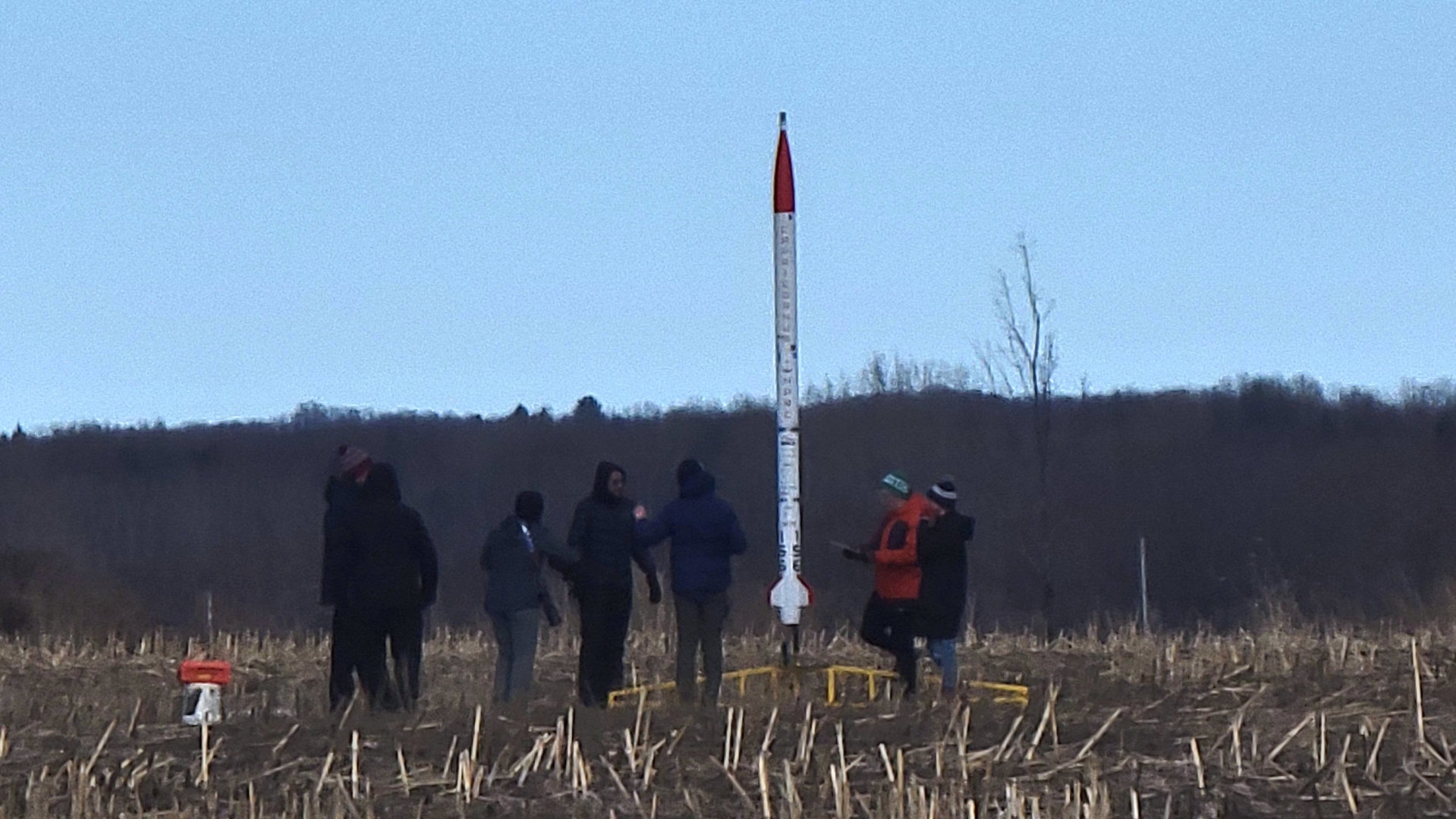The Deneb rocket on the launch pad; for size comparison next to students
